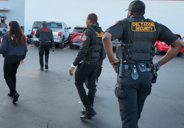 A group of men in black suits walking on the street.