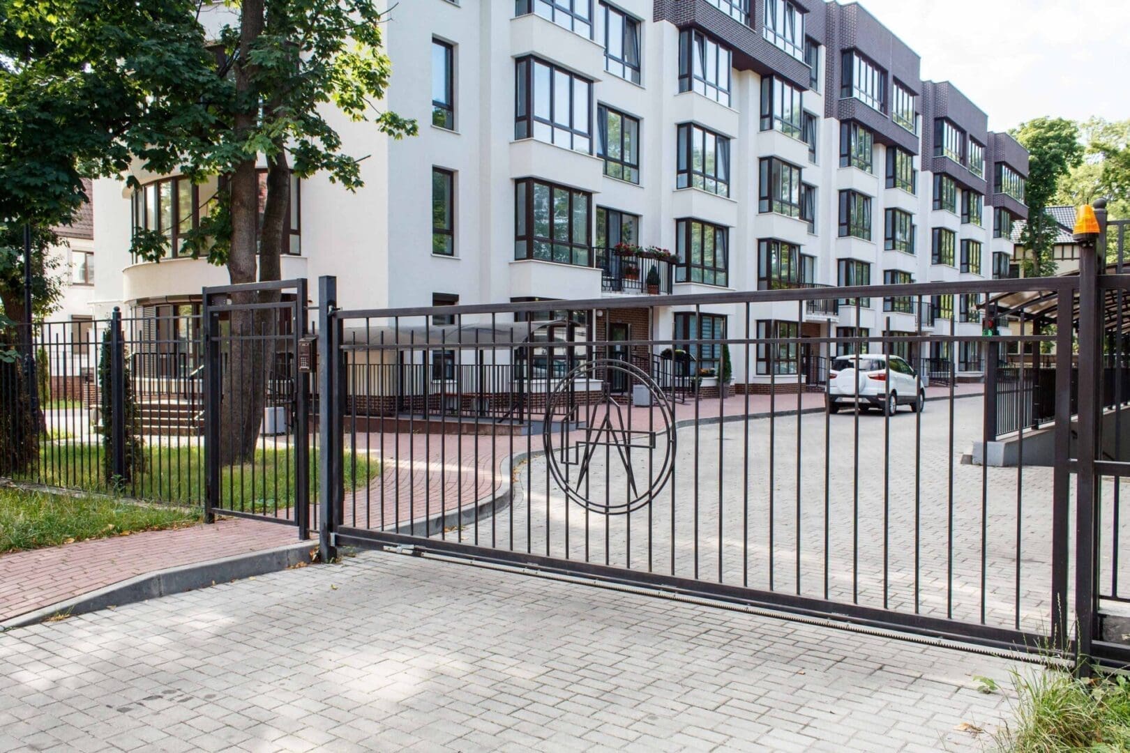 A bicycle is locked to the gate of an apartment complex.