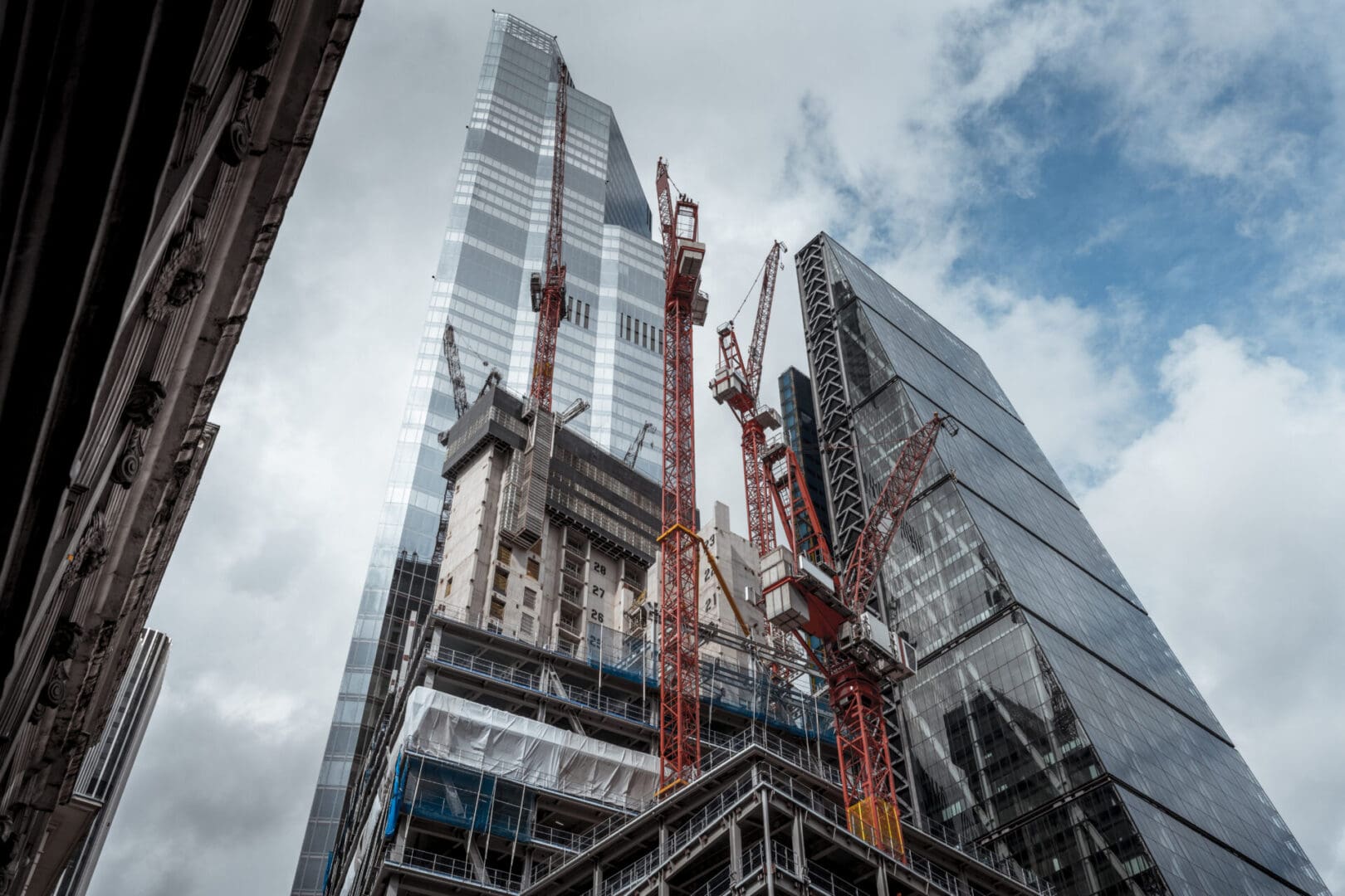 A building under construction with many cranes on it.