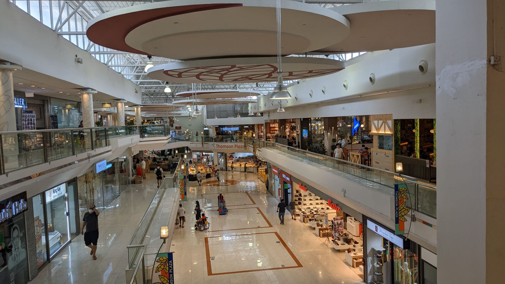 A mall with many people walking around it