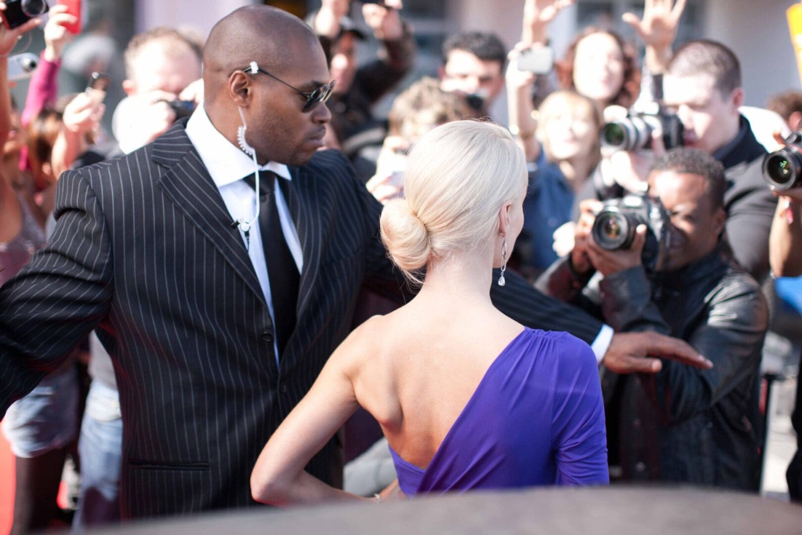 A man and woman are standing in front of a crowd.