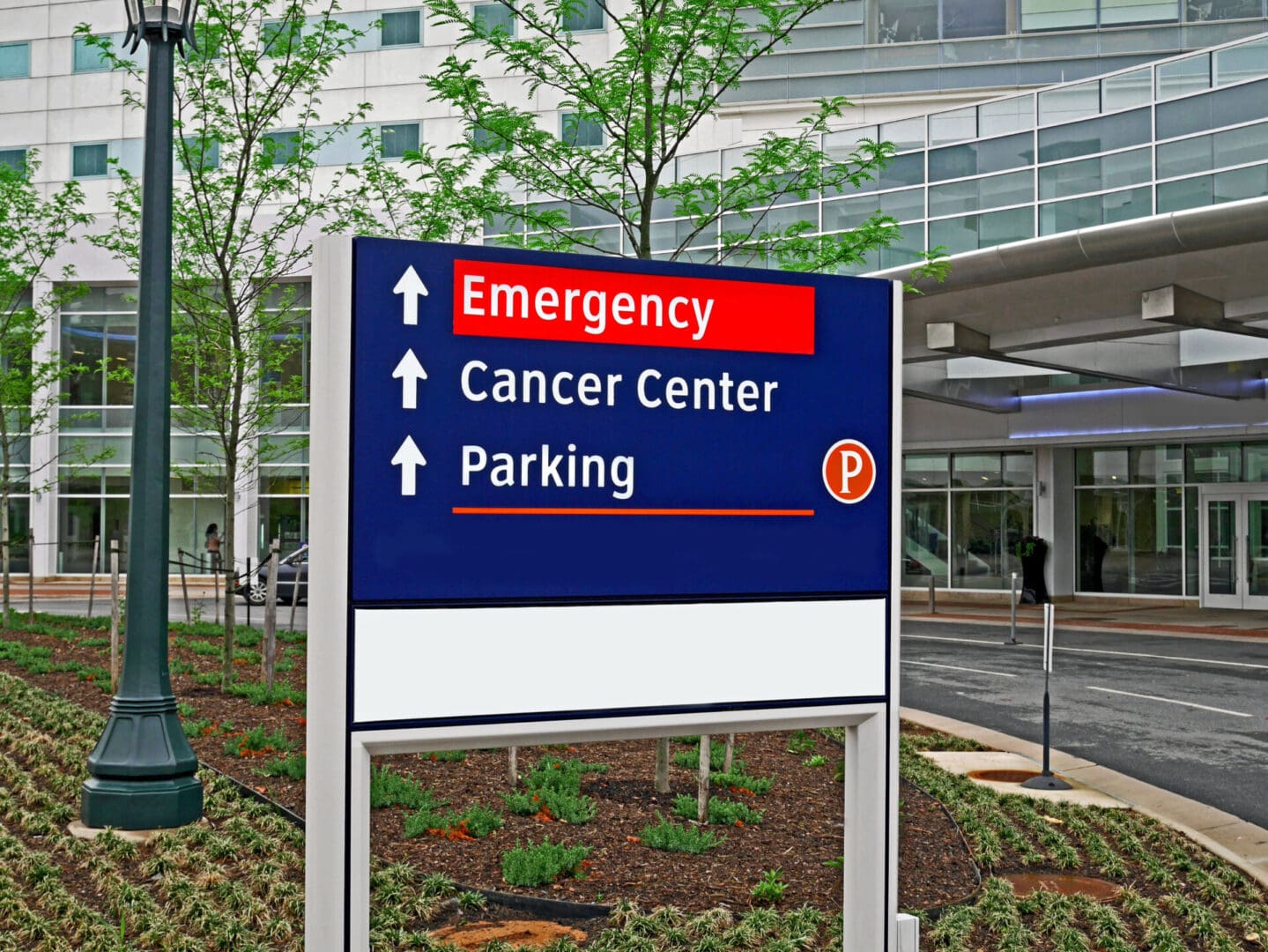 A hospital sign in front of the entrance to an emergency room.